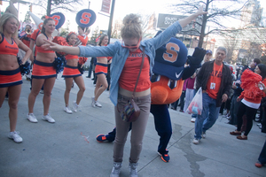 Sarah Eckhardt, a freshman at Syracuse University, dances with Otto the Orange outside of The Hudson Grille in Atlanta Georgia.