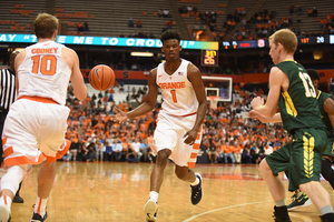 Franklin Howard dumps a pass off to Trevor Cooney. The Orange shot 32 3-pointers in the exhibition win over Le Moyne. 