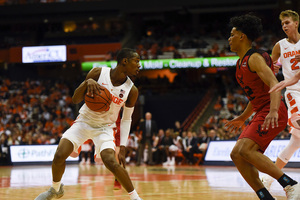 Jalen Carey dribbles the ball at the top of the key.