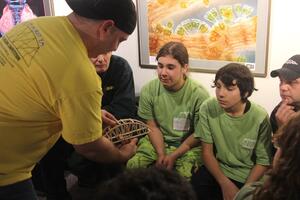 Emerson Shenandoah (center) looks on during the bridge-making process. 