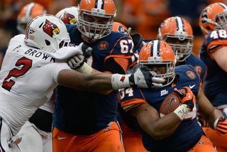 Syracuse running back Adonis Ameen-Moore has his facemask yanked by Louisville's Preston Brown in the Orange's 45-26 upset win.