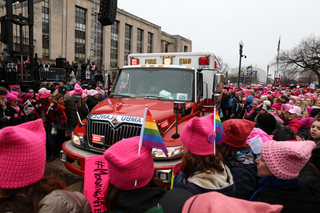 Protesters work together to make way for an ambulance to get through the crowd.