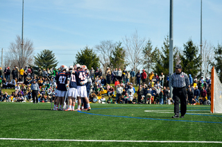 Syracuse huddles up on the field. 