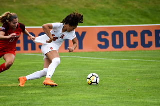 A Fairfield player tries to hold back an SU player.